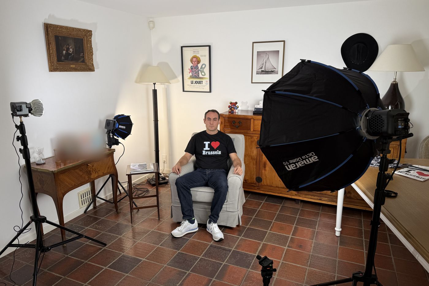 Coulisses d'une interview vidéo chez un client : invité assis dans un fauteuil, éclairé par trois lumières dont une grande softbox